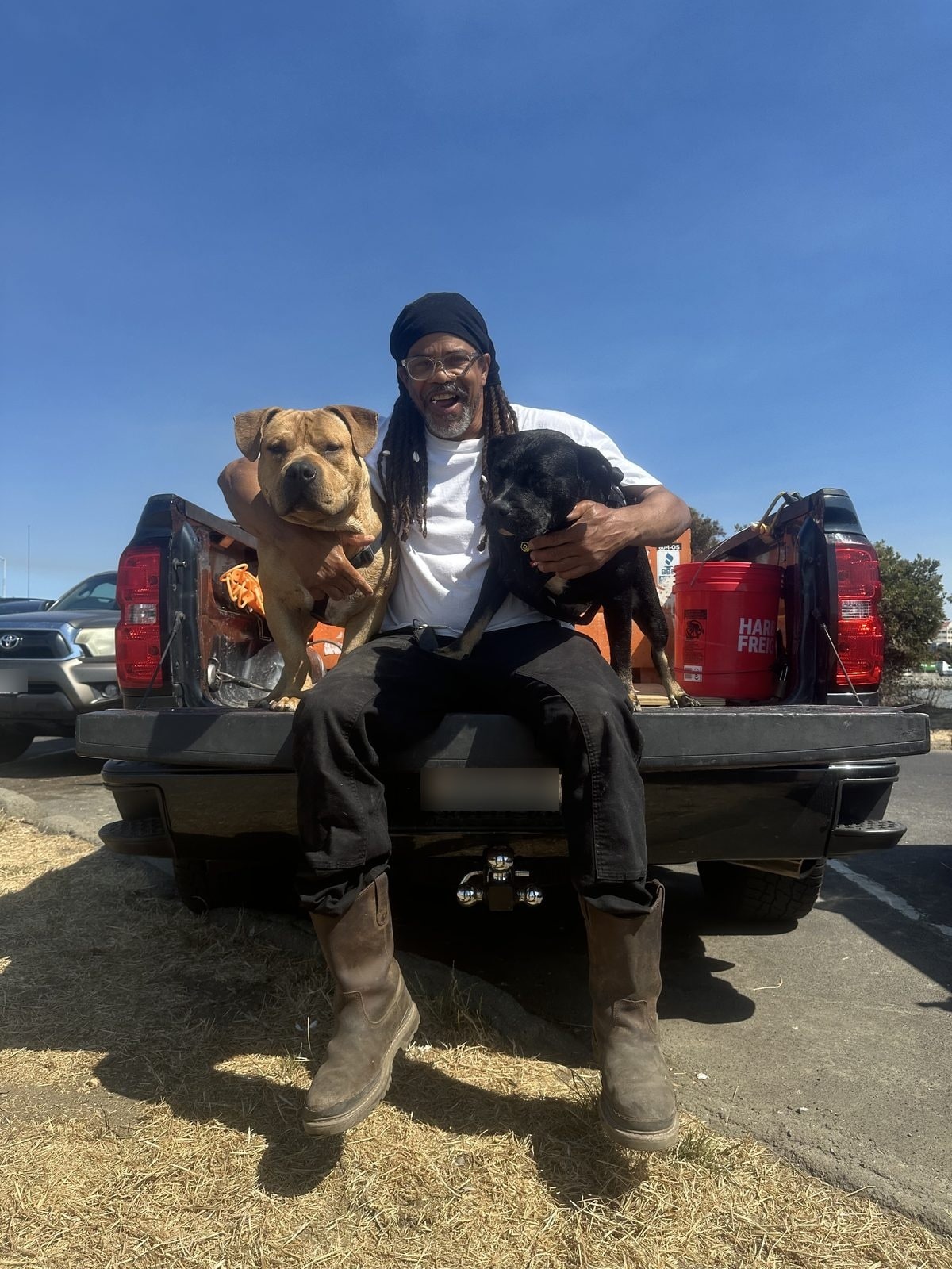 Seanery Donaville, owner of Depth Concrete Inc, with his two dogs